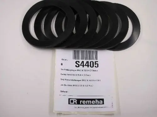Mehrere schwarze Dichtungen auf einem weißen Hintergrund, verpackt mit einem Etikett von Remeha. Das Etikett enthält Artikelnummer und Maße.